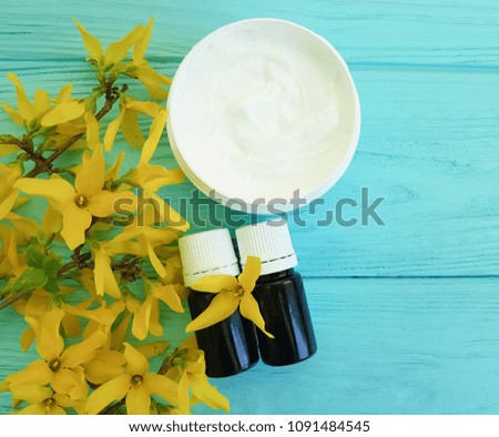 cream cosmetic yellow flowers on a blue wooden background, extract