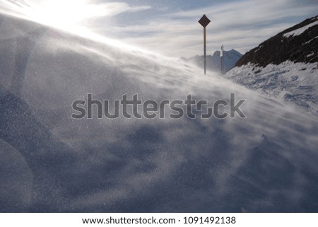 Strong wind blowing snow on the mountain ski route