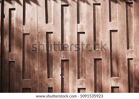The sun light on the old wooden wall of Thai's traditional house with uniqueness pattern design showing the wood abstract texture