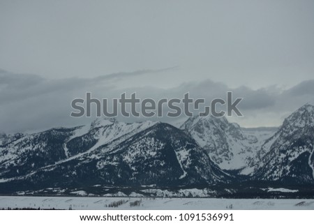 white snow cloudy sky  and moutain in background