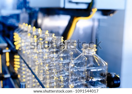 Bottle. Industrial production of plastic pet bottles. Factory line for manufacturing polyethylene bottles. Transparent food packaging. Royalty-Free Stock Photo #1091544017