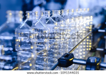 Bottle. Industrial production of plastic pet bottles. Factory line for manufacturing polyethylene bottles. Transparent food packaging. Royalty-Free Stock Photo #1091544035