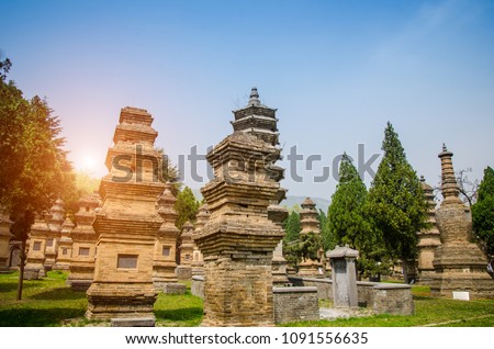 Pagoda forest is ancient mortuary urn of former abbot of the Shaolin Monastery temple with tree,sunlight and blue sky background,China.