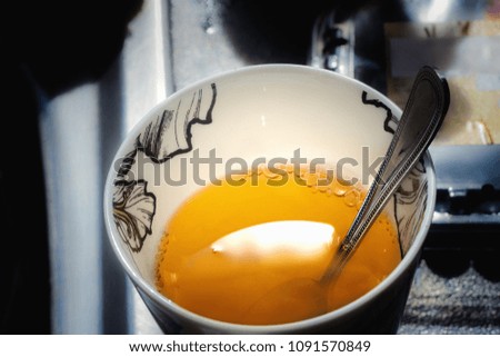 Close view of white cup with a teaspoon and dissolved gelatin in hot water