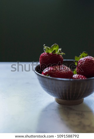 strawberries in a bowl on marble counter top