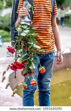 Young boy carries a bouquet with roses
