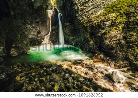 Famous cave waterfall Kozjak on So?a river, Slovenia. Motion blur photo of a waterfall in Julian Alps, Slap Kozjak. Blurred water, green and blue colors.  Royalty-Free Stock Photo #1091626952