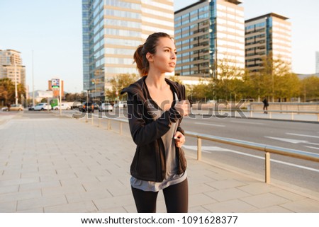 Photo of amazing beautiful young sports woman running outdoors on the street.