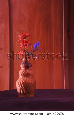 Plastic flowers with wooden background in vintage picture style