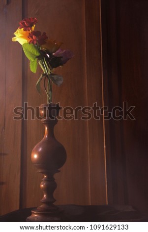 Plastic flowers with wooden background in vintage picture style