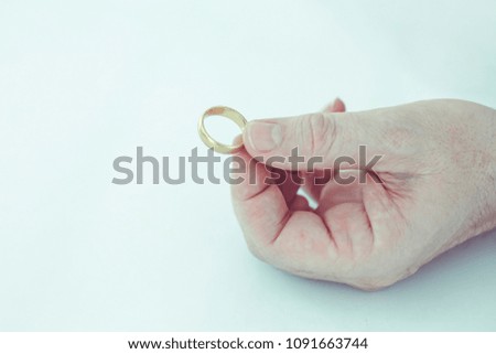 A man hand holding golden wedding ring on white background