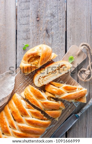 Traditional pie with cabbage for Russian cuisine- Kulebyak on a wooden table, cut, selective focus, top view, copy space