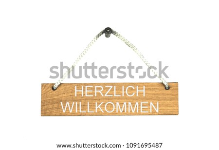 Old brown isolated wooden sign with rope showing Welcome in german language