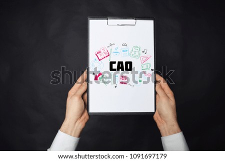 In the hands of a businessman a notebook with the inscription:CAO