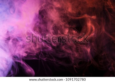 Colorful pink,red and blue smoke  on a black isolated background. Background from the smoke of vape
