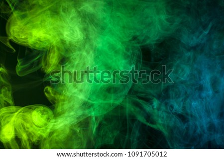 Blue and green  cloud of smoke of  black isolated background. Background from the smoke of vape

