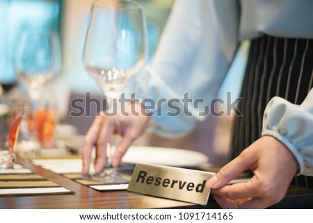 Hand with Reserved Table. Elegant Restaurant Table Setting Service for Reception with Reserved Card.