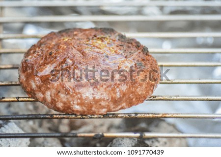 Close up cooking pork meat barbecue burger on the grille with soft fire.