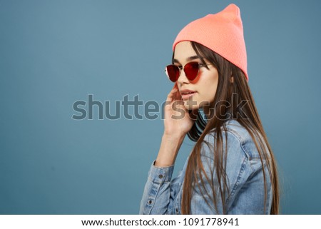 fashionable brunette with glasses and a pink hat