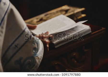 Priest stands with a Bible during the wedding ceremony