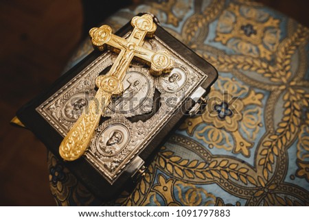 Golden cross lies on the Bible in church