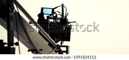 Behind the scenes of video production in the big studio with professional equipment such as camera tripod and crane.