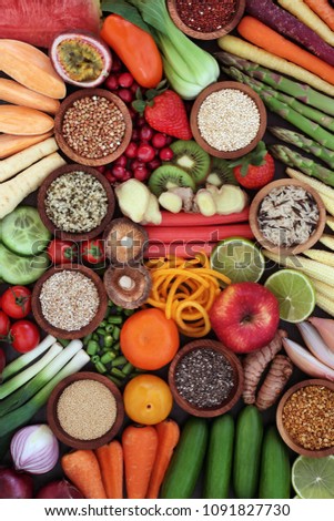 Large healthy super food selection to promote good health concept with grains, seeds, pollen grain, fresh vegetables & fruit forming an abstract background. High in antioxidants, anthocyanins & fibre.