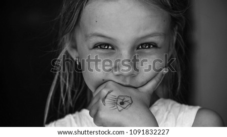 The girl looks at the anphase by biting her hand with her personal picture on it black and white
