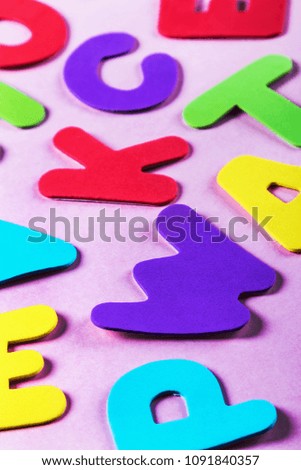 letters of the alphabet in different colors on a pink background