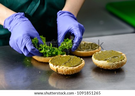 Unidentified chef preparing appetizing burgers