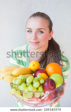 Young woman with a bowl full of fresh fruits
