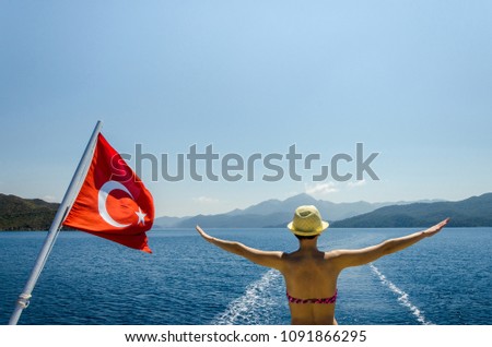 Stylish freedom woman in yellow hat show freedom on sea summer panorama on yacht with Turkey flag of rest in sea bay blue calm mood on vocation wild nature beach palms view Royalty-Free Stock Photo #1091866295