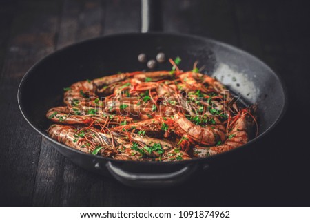 Shrimps fried in a pan. Classic recipe - parsley, garlic, chilli