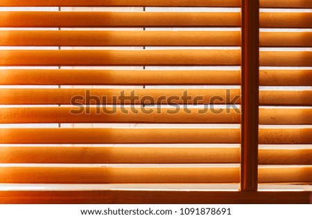 Wooden sun blinds on window with sun light 