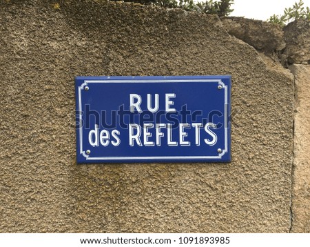 Metallic street board in France, meaning street of reflections.