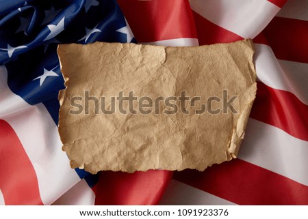 elevated view of vintage blank crumpled paper on american flag 