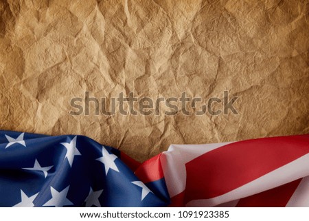 top view of old crumpled paper and united states flag
