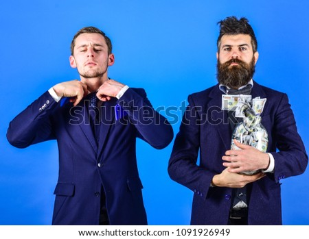 Crediting concept. Men in suit, businessmen with jar full of cash and credit card, blue background. Mature man prefers cash, modern guy recommends credit card, electronic money