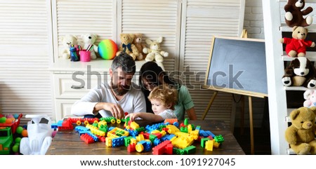 Family and childhood concept. Young family spends time in playroom