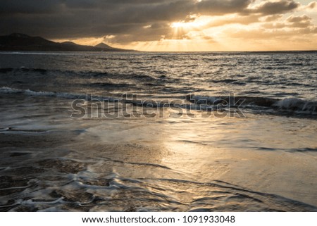Seaside in Gran Canaria; evening view on the sea with ocean water splashing against the beach 
