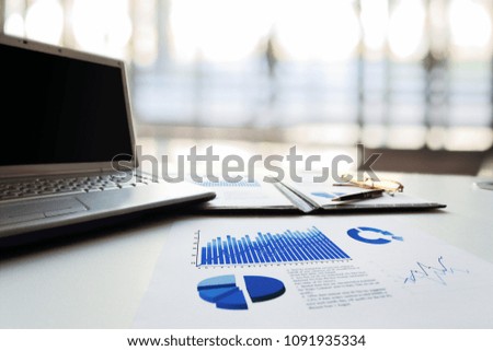financial report,laptop and pen at workplace businessman