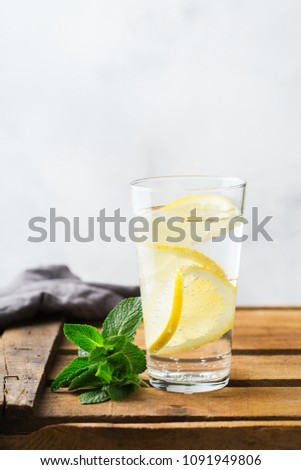 Health care, fitness, healthy nutrition diet concept. Glass of fresh cool lemon infused water, detox drink, lemonade in for breakfast in spring summer days on a table. Copy space background