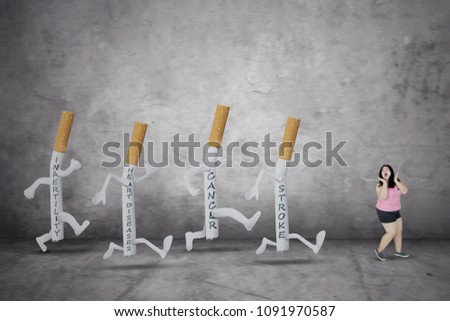 Picture of fat woman looks scared while being chased by diseases on cigarettes