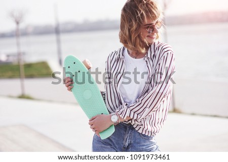 Beautiful teen female skater on ramp at the skate park. Concept of summer urban activities.