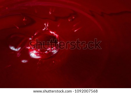 splash of red wine closeup of bright drops flying in different directions an alcoholic drink made from grapes