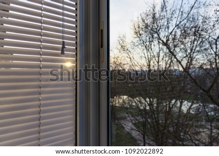 closed plastic blinds on the window with the reflection in the glass