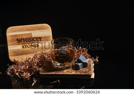 Irish whiskey. Glass of whisky with wiskey stones. Wiskey stones on black background. Elegant glass of whiskey . Whisky stones in wooden box.
