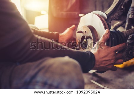Selective focus disc brake on car, in process of new tire replacement,Car brake repairing in garage Royalty-Free Stock Photo #1092095024
