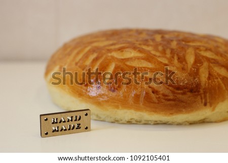 round homemade bread on white background. inscription home made