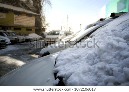 Car covered with frosty white snow in the parking